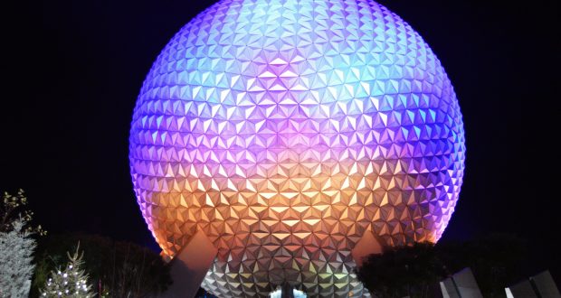 Spaceship Earth lights up the Epcot night, vibrant against the sky—an unmissable Disney World icon for theme park fans.