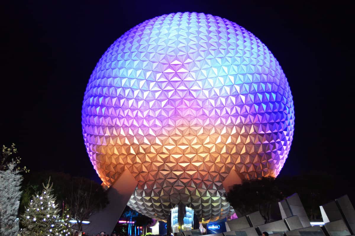 Spaceship Earth lights up the Epcot night, vibrant against the sky—an unmissable Disney World icon for theme park fans.