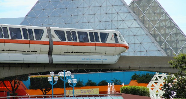 The classic white and orange Disney monorail cruises past Epcot’s futuristic glass pyramids, a must-see for theme park fans.