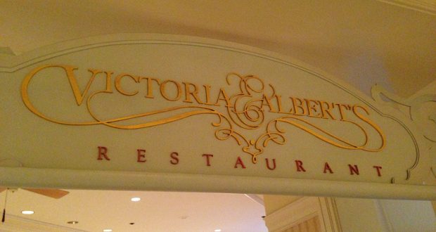 Victoria & Albert's Restaurant sign in elegant gold and red lettering, welcoming Disney fans to upscale dining at the Grand Floridian.