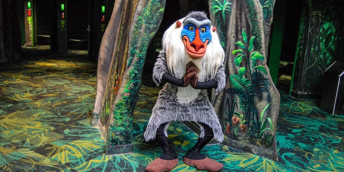 Rafiki from The Lion King greets guests in a lush, Animal Kingdom-inspired jungle setting celebrating hidden gems.