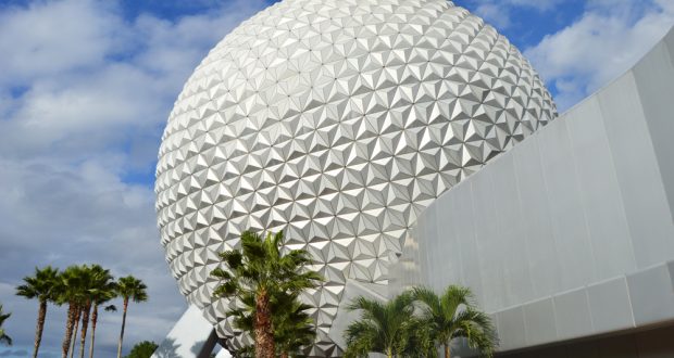 Spaceship Earth at EPCOT, framed by palm trees under a partly cloudy sky—a must-see for Disney fans and perfect photo ops!.