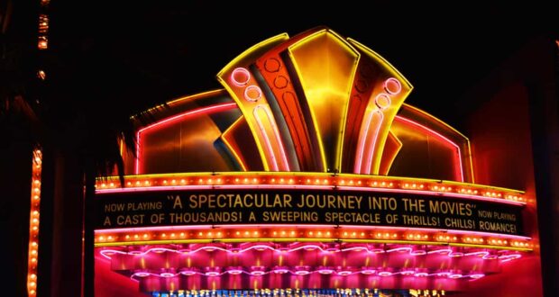 Neon marquee glows “A Spectacular Journey Into the Movies,” welcoming fans to Hollywood Studios’ enchanting nighttime magic.