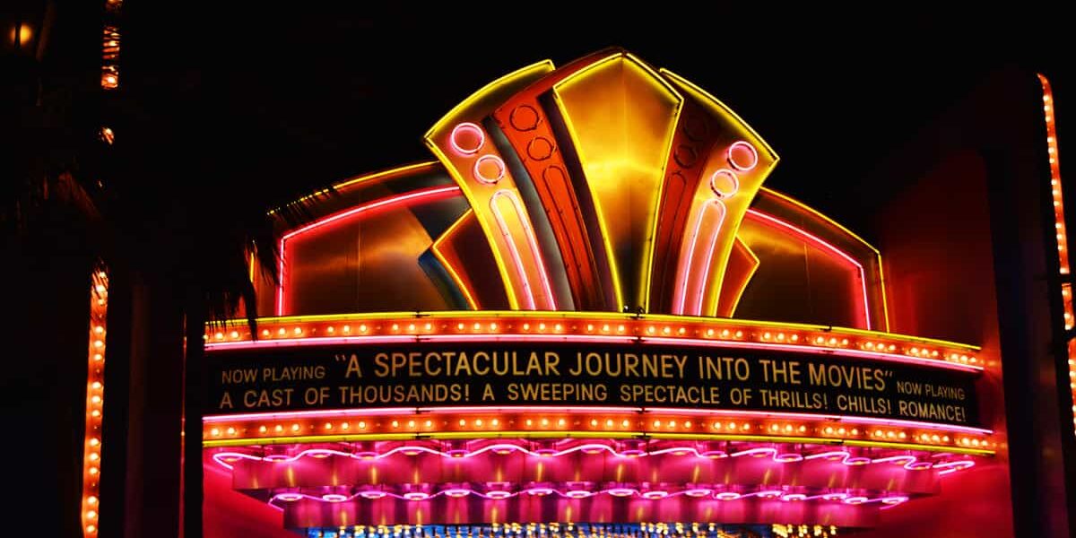 Neon marquee glows “A Spectacular Journey Into the Movies,” welcoming fans to Hollywood Studios’ enchanting nighttime magic.