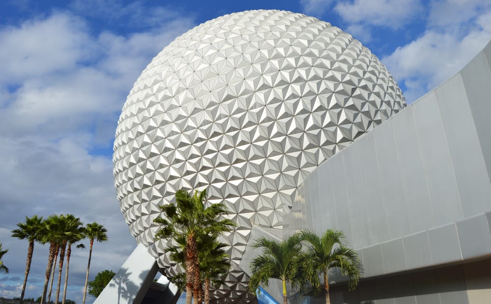 Spaceship Earth’s iconic geodesic dome at EPCOT, soaring against palm trees and a bright blue Florida sky.