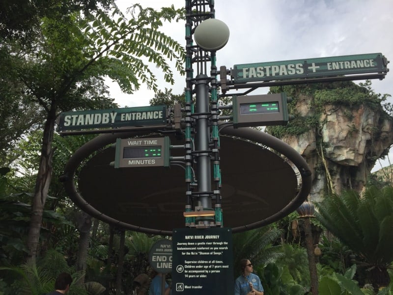 Avatar Flight of Passage entrance signs for Standby and FastPass+ lineups, set amid lush greenery in Disney’s Animal Kingdom.