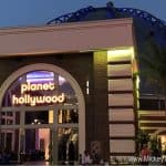 Planet Hollywood Observatory glowing at dusk, neon lights shining as Disney World guests gather outside for a night of fun.