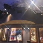 Music memorabilia like famous outfits, a guitar, and photos fill glass cases beneath the iconic Planet Hollywood balcony at Disney World.