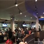 Guests mingle and sip cocktails at Planet Hollywood Observatory’s lively bar, TVs glowing, steps from Disney World excitement.