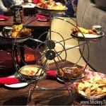 A Ferris wheel appetizer server spins at Planet Hollywood Observatory, with Disney World guests dining in the lively background.