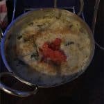Creamy spinach dip in a metal bowl with diced tomatoes at Planet Hollywood Observatory, an ideal Disney World shareable snack.