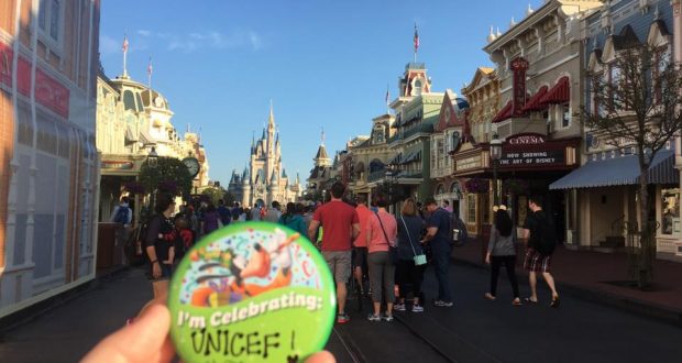 I'm Celebrating: UNICEF!" button showcased in front of the castle and It's a Small World at Disney, supporting UNICEF fundraising.