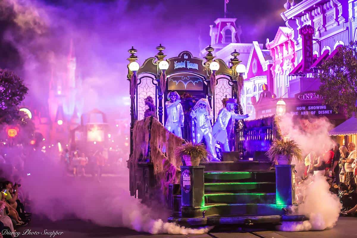 A chilling parade float with eerie ghosts and swirling fog drifts down Main Street, framed by Disney World's glowing nightlife.