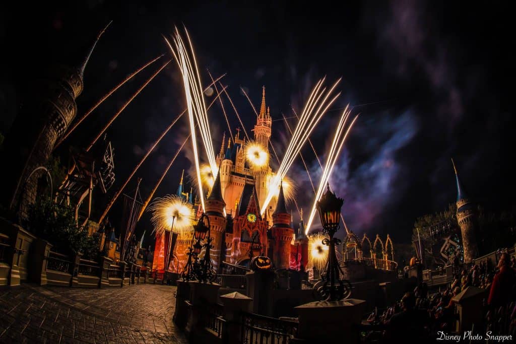 Fireworks illuminate Cinderella Castle during Mickey’s Not-So-Scary Halloween Party at Magic Kingdom, crowds lining Main Street.