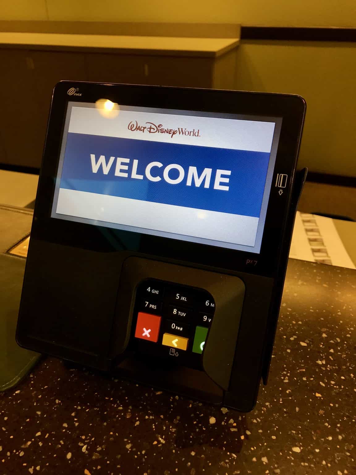 A Walt Disney World payment terminal welcomes guests, showcasing the park’s upgraded, guest-friendly payment technology.
