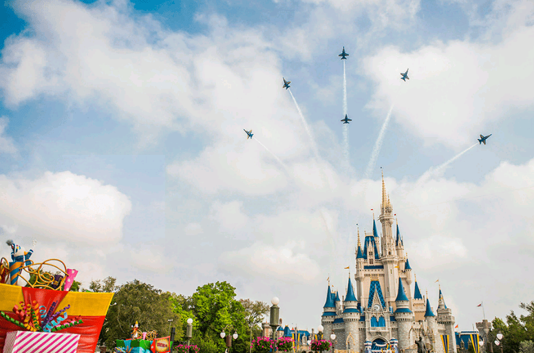 Blue Angels soar in tight formation over Cinderella Castle at Walt Disney World, dazzling guests during a vibrant daytime parade.