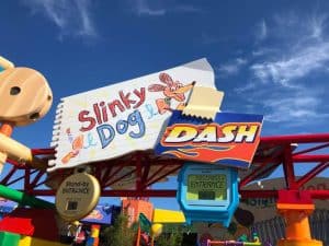 Slinky Dog Dash entrance sign pops with color beneath a sunny sky, welcoming guests to the fun of Disney’s Hollywood Studios.
