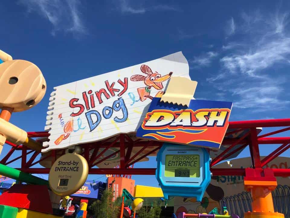 Slinky Dog Dash entrance sign pops with color beneath a sunny sky, welcoming guests to the fun of Disney’s Hollywood Studios.