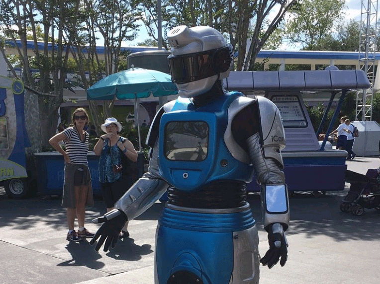 ICan the Robot delights guests outside among lively vendor booths, its silver and blue suit gleaming at the festival.