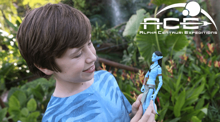 Young guest with an Avatar action figure at Pandora—The World of Avatar, Alpha Centauri Expeditions logo visible, ready for adventure!.