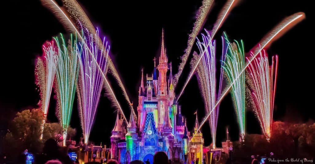 Cinderella Castle at Magic Kingdom illuminated at night, as dazzling fireworks burst in vibrant colors overhead.