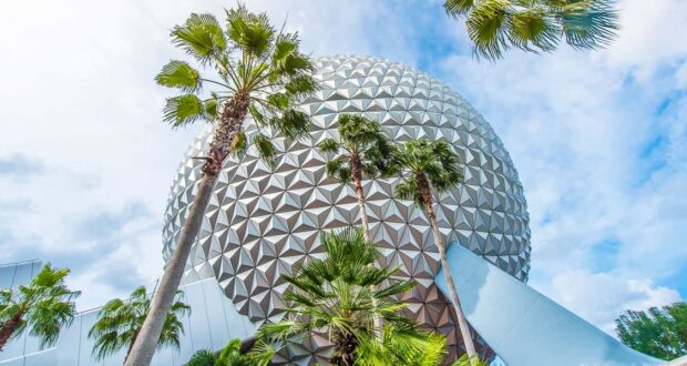 Spaceship Earth at Epcot rises above palm trees under a partly cloudy sky, capturing the magic of Walt Disney World adventure.