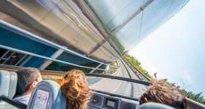 Guests race along an outdoor track in a sleek ride vehicle, zipping past gleaming metal walls in true Disney World thrill-ride style.
