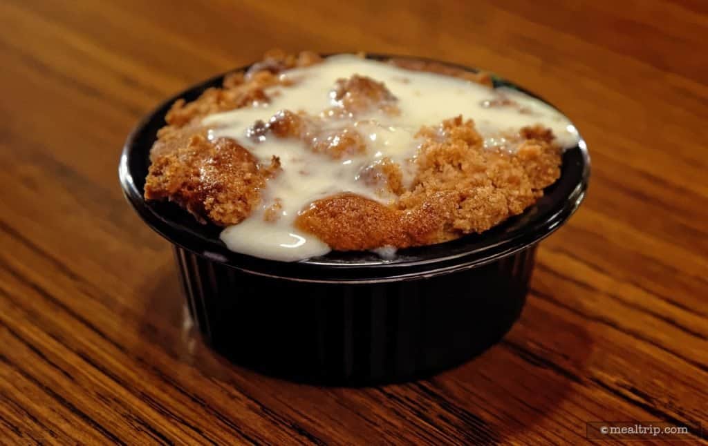 Delight in warm bread pudding with creamy white sauce, served in Liberty Square—an iconic Magic Kingdom treat!.
