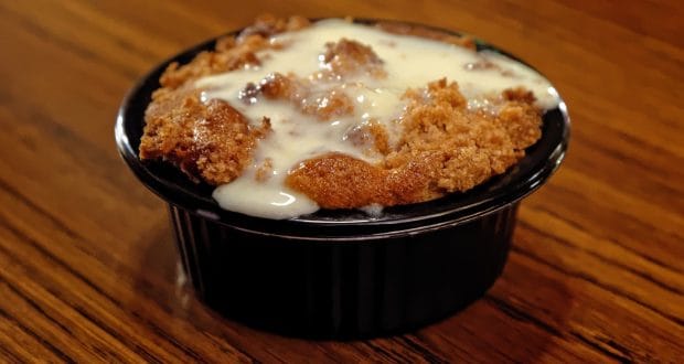 Delight in warm bread pudding with creamy white sauce, served in Liberty Square—an iconic Magic Kingdom treat!.