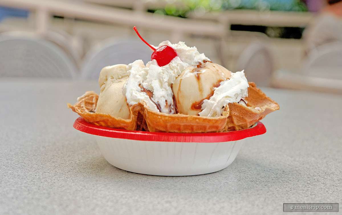 Vanilla ice cream in a waffle bowl, topped with whipped cream, chocolate syrup, and a cherry—a Magic Kingdom fan favorite treat.
