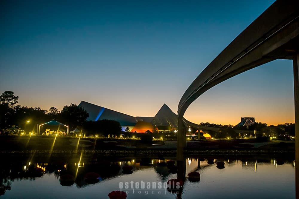 Epcot’s Spaceship Earth and monorail glow at sunset, their reflections shimmering on World Showcase Lagoon—a Disney must-see.