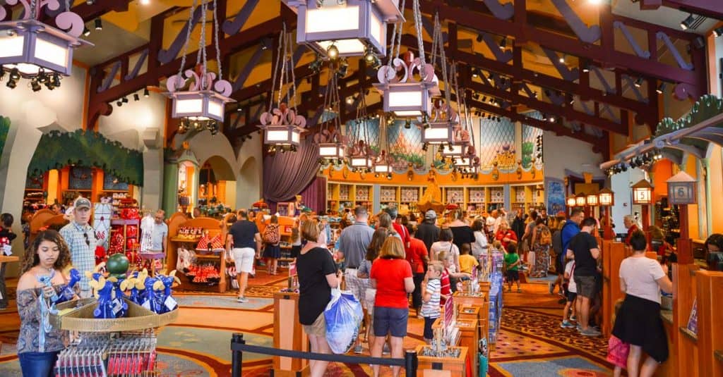 Guests browse for Disney-themed merchandise beneath soaring wooden beams in a vibrant gift shop at Walt Disney World.