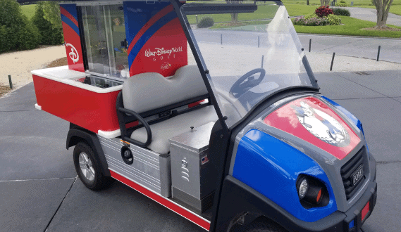 Eye-catching Disney golf cart in red, blue, and silver sits ready for adventures along Walt Disney World’s scenic paths.