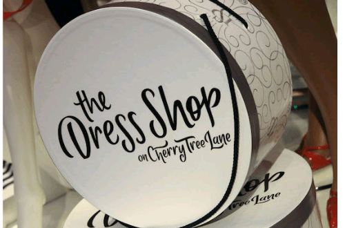 Round white box with "The Dress Shop on Cherry Tree Lane" in black script—a magical piece from Disney World's Dress Shop line.