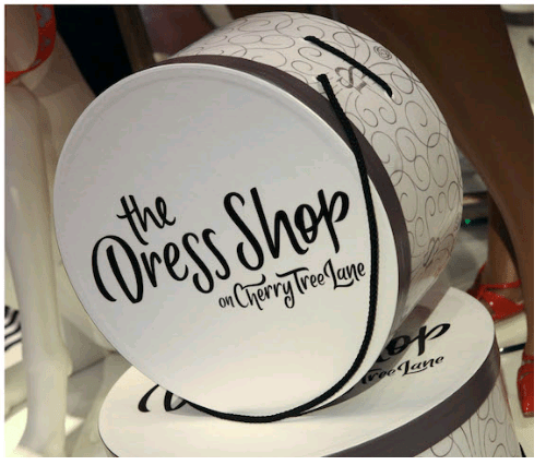 Round white box with "The Dress Shop on Cherry Tree Lane" in black script—a magical piece from Disney World's Dress Shop line.