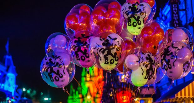 Mickey Mouse "BOO" balloons light up the Disney World night, surrounded by festive park lights for unforgettable memories.