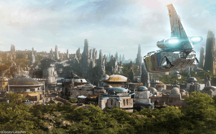 Star Wars: Galaxy’s Edge skyline with towering rocky spires and a spaceship soaring above, set against a bright blue sky.