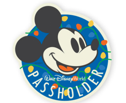 Mickey Mouse beams on a blue Disney World Passholder badge, framed by bright holiday lights—a festive Annual Passholder magnet.