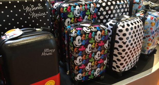 Disney-themed suitcases featuring Minnie and Mickey Mouse, displayed on a store table—ideal for your next Walt Disney World trip.