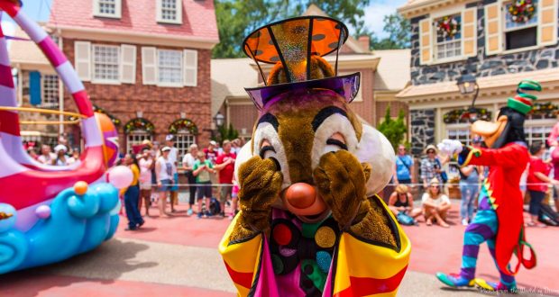 Chip and Dale, dressed in vibrant parade costumes, playfully cover their eyes while delighting Disney World parade guests.
