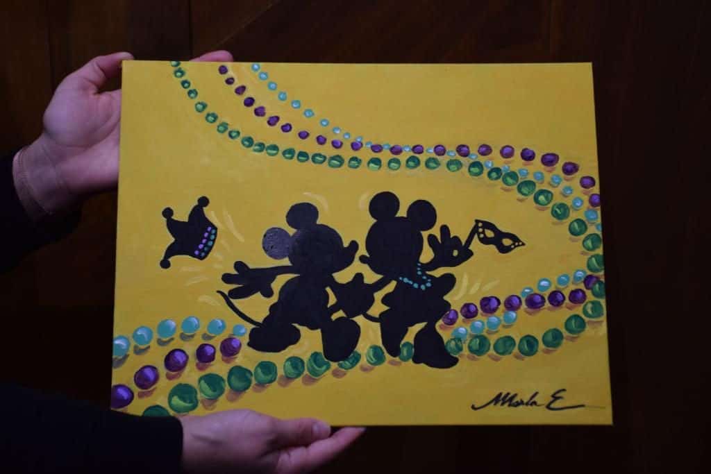 Mickey and Minnie Mouse silhouettes with Mardi Gras beads evoke Port Orleans flair, set on a vibrant yellow backdrop at Disney World.