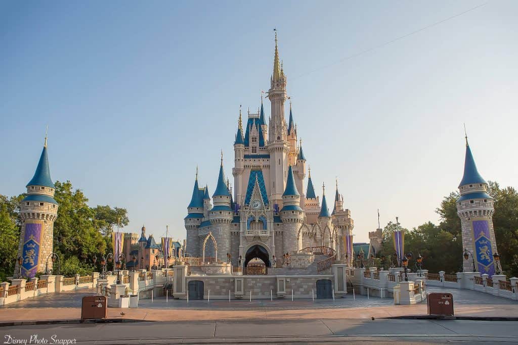 Cinderella Castle at Magic Kingdom dazzles with blue spires, welcoming guests under a sunny sky in the heart of Disney World.