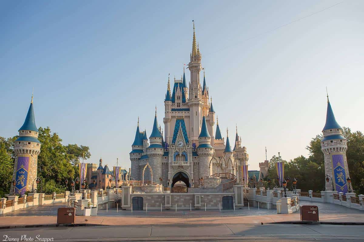 Cinderella Castle at Magic Kingdom dazzles with blue spires, welcoming guests under a sunny sky in the heart of Disney World.