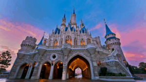 Cinderella Castle glowing at sunset with vibrant skies—catch this iconic Disney World view or stream it live on DisneyParksLIVE.