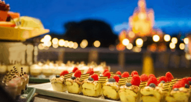 Gourmet berry-topped desserts line outdoor tables at Magic Kingdom, sparkling under bokeh lights during a Fireworks Dessert Party.