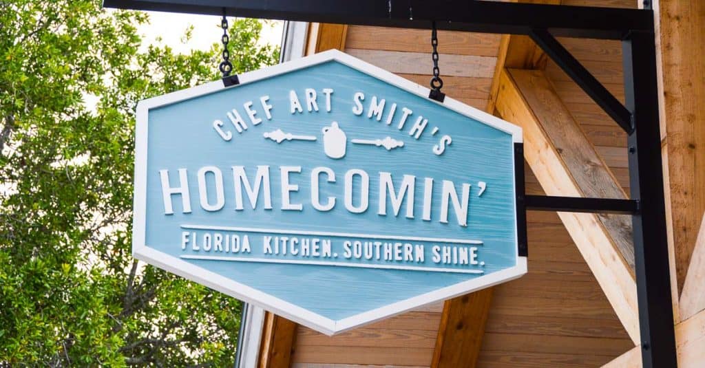 Chef Art Smith’s Homecomin’ Florida Kitchen blue sign shines at Disney Springs—inviting guests to try Southern favorites.