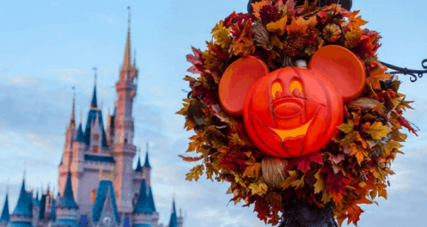 Mickey Mouse pumpkin and autumn leaves in front of Cinderella Castle celebrate the festive Disney Fall Into Magic at Walt Disney World.