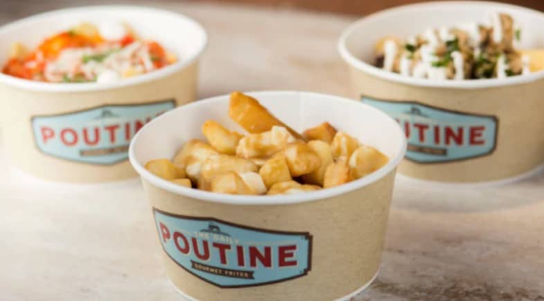 Three bowls of classic poutine served in "Poutine" containers—Disney World comfort food perfect for your next snack break!.