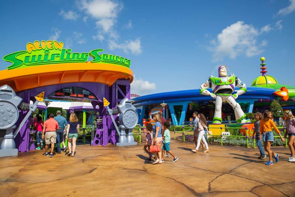 Guests stroll past the Alien Swirling Saucers attraction and Buzz Lightyear statue in Toy Story Land at Disney’s Hollywood Studios.