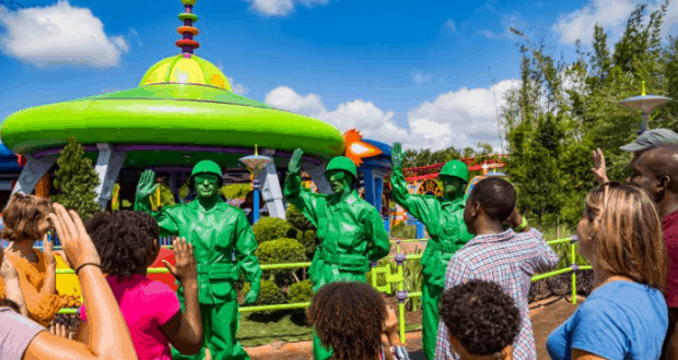 Guests wave at the Green Army Patrol from Toy Story Land in Disney’s vibrant theme park attraction.